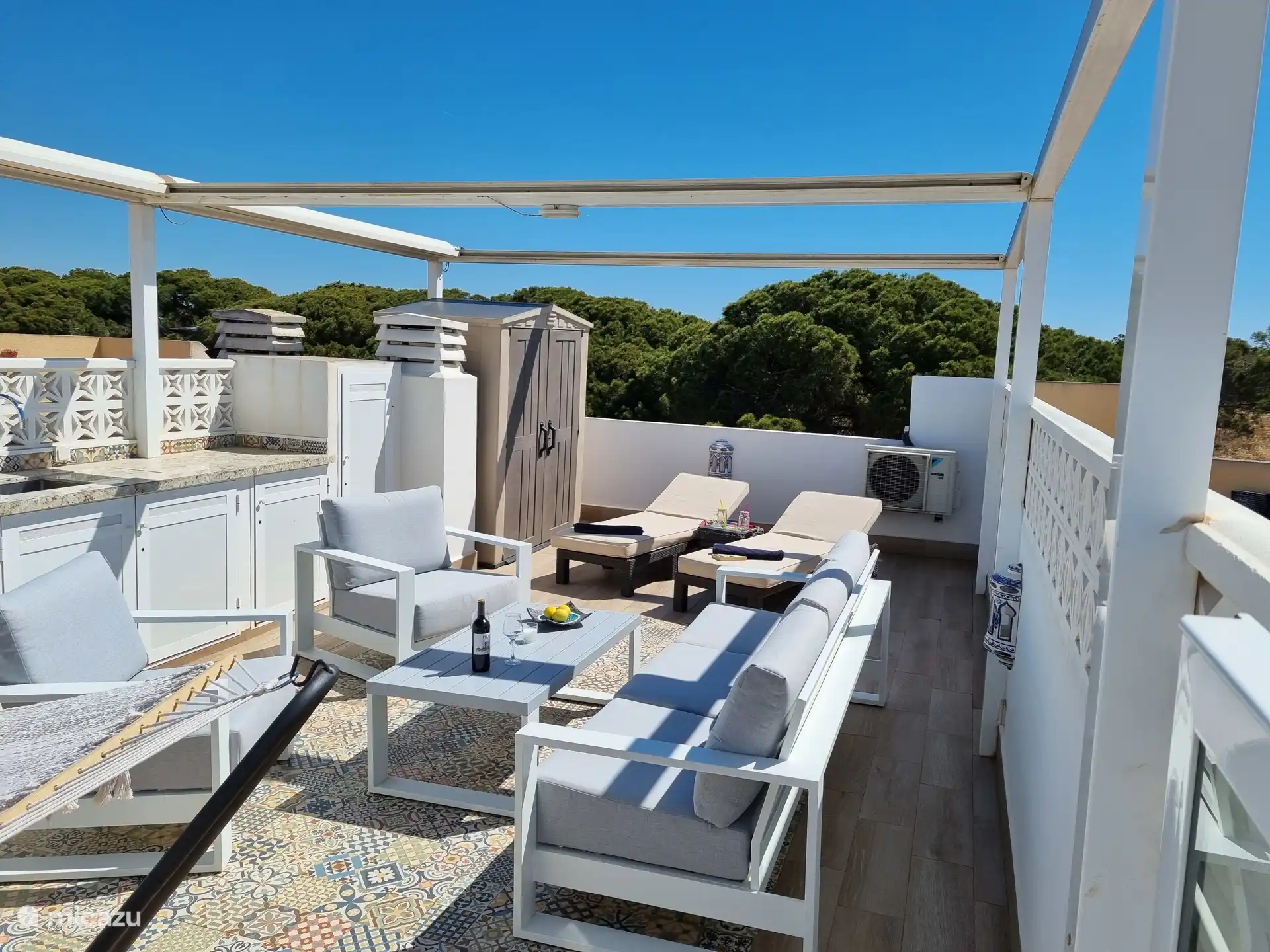 Wie schön ist es, auf der Dachterrasse zu entspannen! Eine Küche mit einem Kühlschrank, Markisen, einem luxuriösen Lounge-Set mit 2 Sonnenliegen und einer Hängematte ist ebenfalls vorhanden. Hier können Sie sich entspannen!  