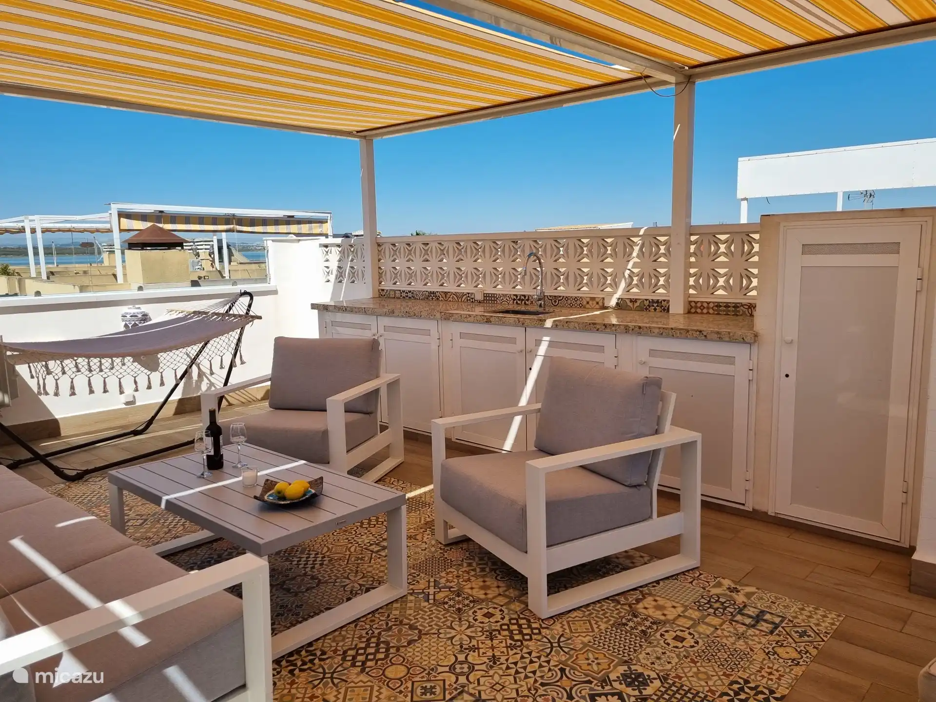 Wie schön ist es, auf der Dachterrasse zu entspannen! Eine Küche mit einem Kühlschrank, Markisen, einem luxuriösen Lounge-Set mit 2 Sonnenliegen und einer Hängematte ist ebenfalls vorhanden. Hier können Sie sich entspannen!  