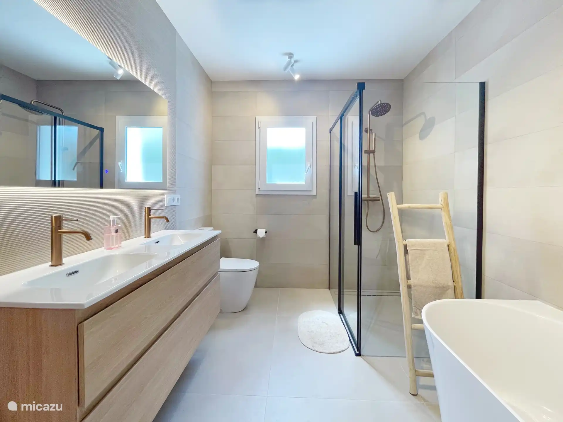 salle de bain luxueuse avec douche à l’italienne, baignoire, double lavabo et toilettes ainsi que chauffage par le sol