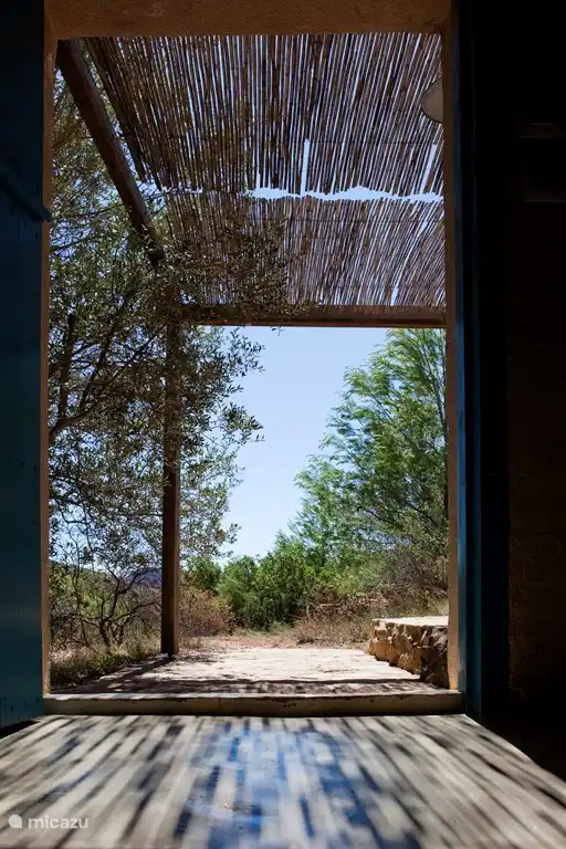 Passage von Haustür zu Terrasse mit gefiltertem Sonnenlicht durch Bambus-Markise, alles in aller Ruhe nur so vergessen