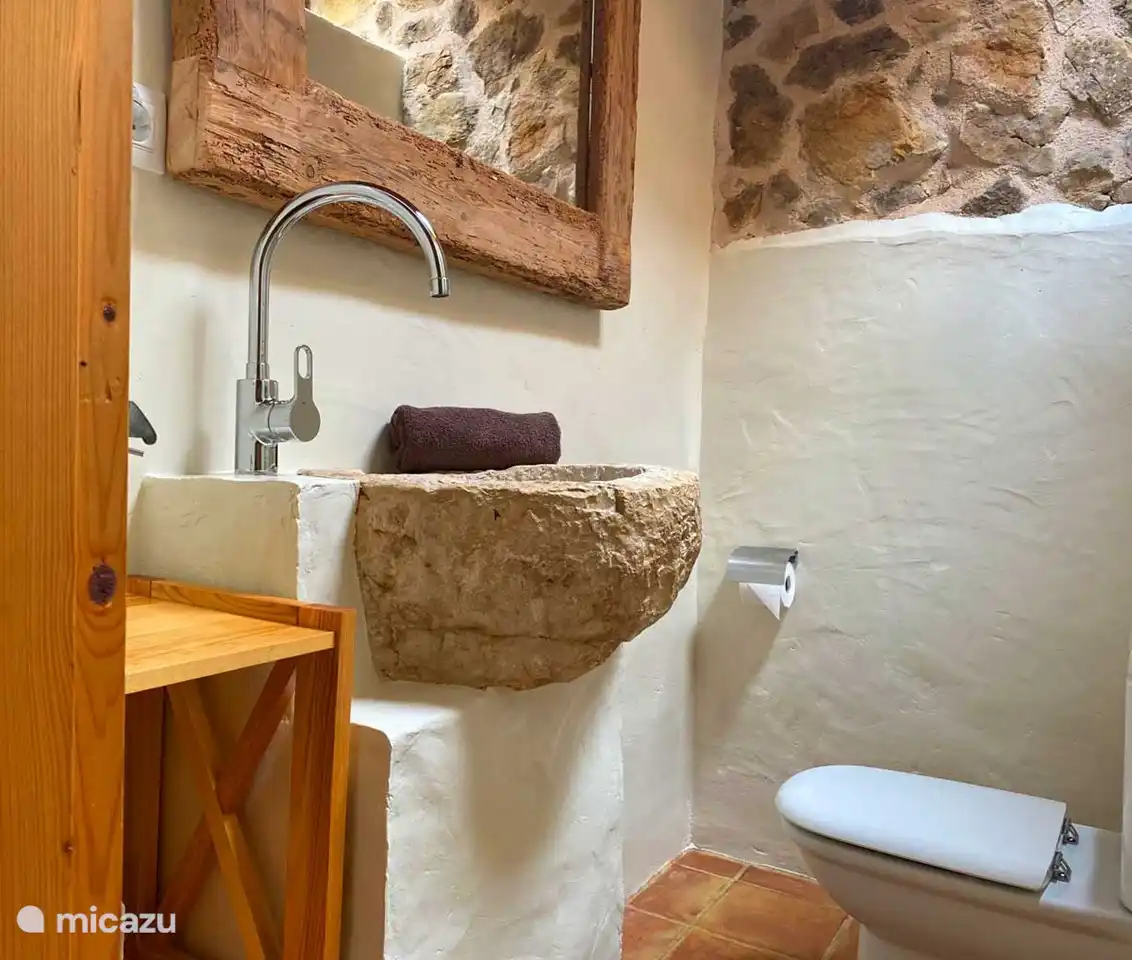 Das rustikale, aber komfortable Badezimmer mit einer antiken Granit-Trinkschale als Waschbecken