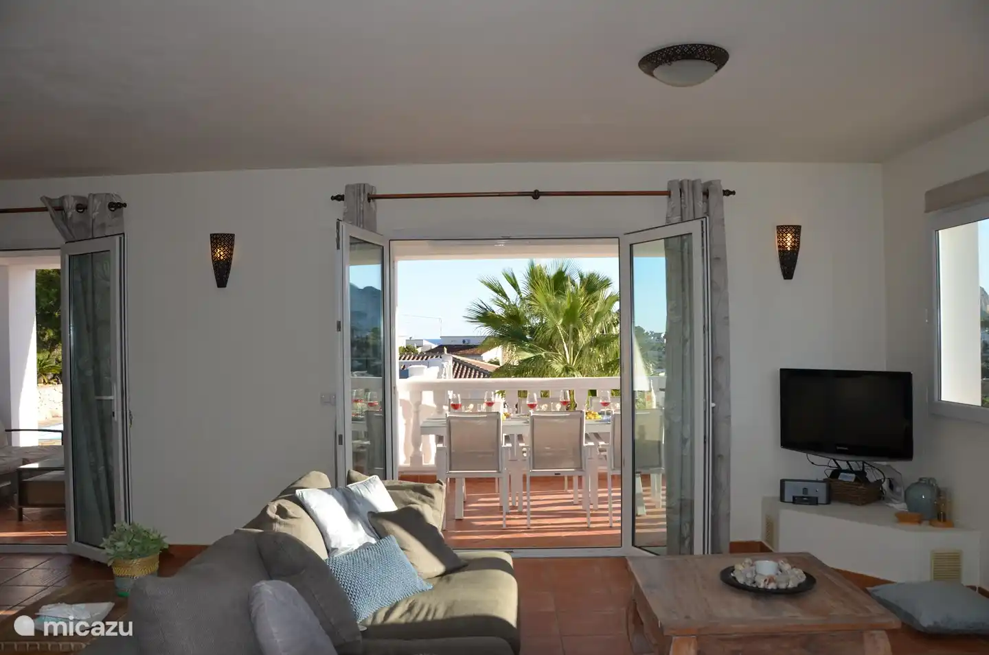 Coin salon avec vue sur la terrasse et la piscine