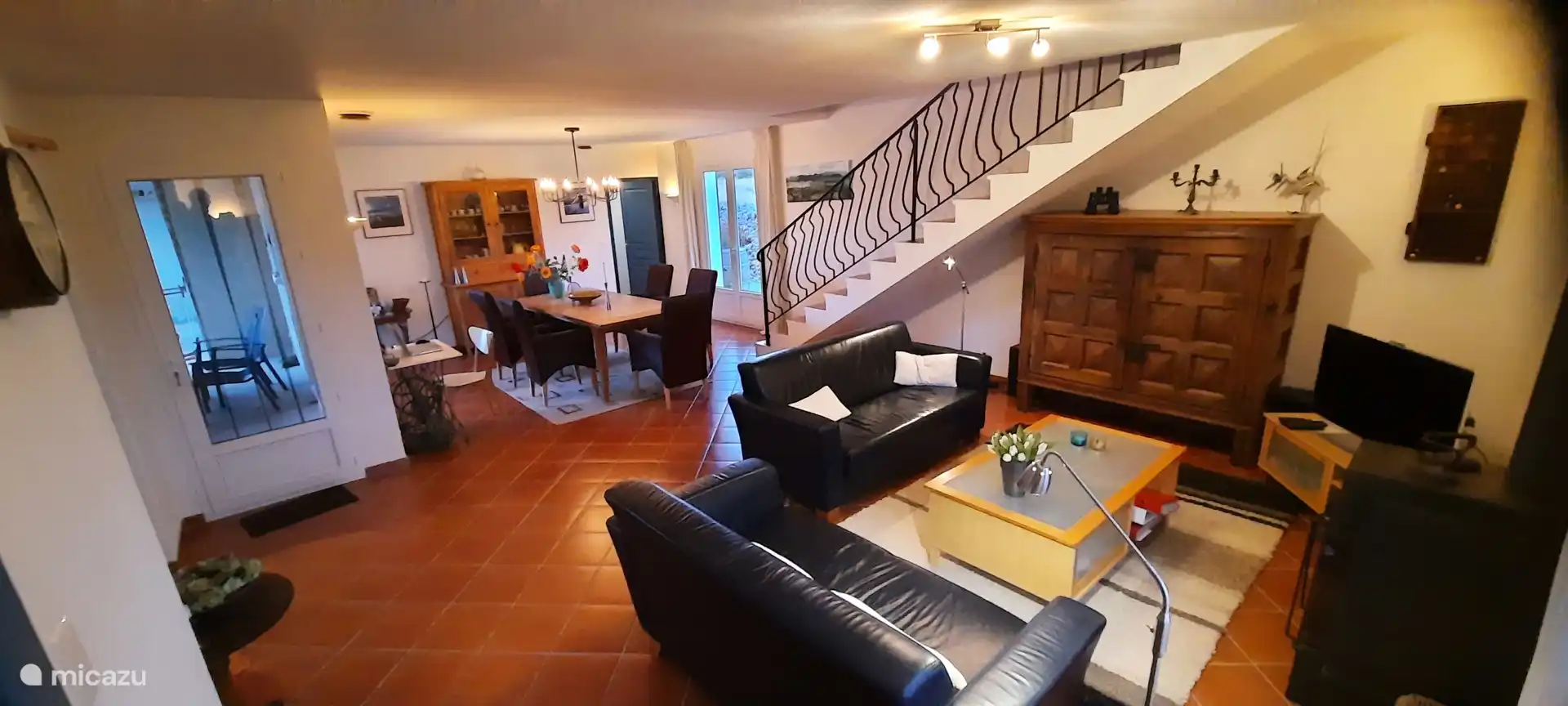 Vue d’ensemble de toute la pièce avec la porte de la terrasse à gauche, et la porte à l’arrière de la villa à droite.