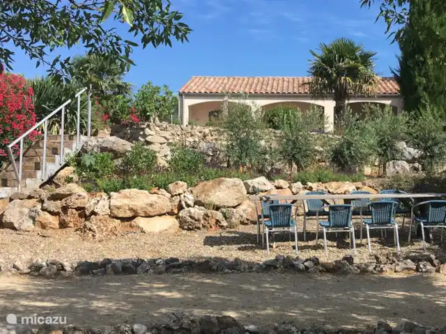 Location de Vacances France, Hérault, Assignan, villa - Pierradore **** Vue depuis le jardin de devant avec des amandiers et le terrain de pétanque. Pierradore est 2 mètres plus haut que le jardin de devant, qui offre une belle vue et beaucoup d'intimité.