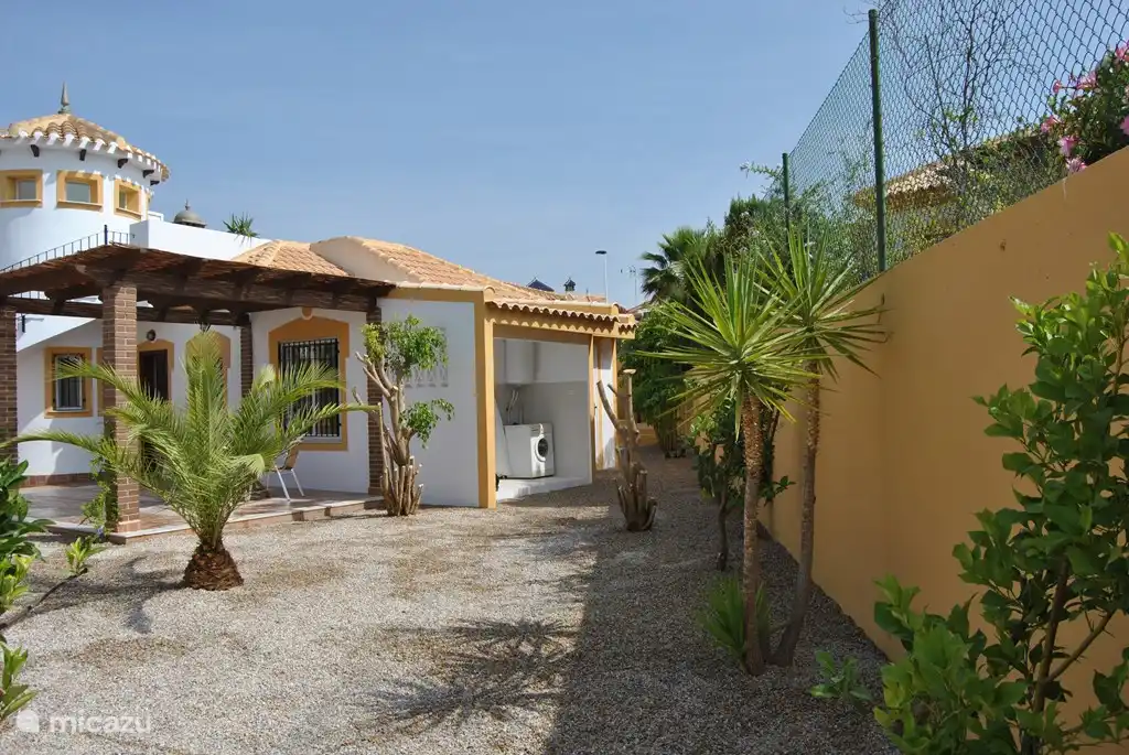 Überdachter Hauswirtschaftsraum mit Waschmaschine, Wäscheleine und allen anderen notwendigen Dingen.