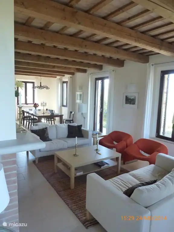 De woonkamer met de open haard, en achterin de grote klassieke Italiaanse eettafel