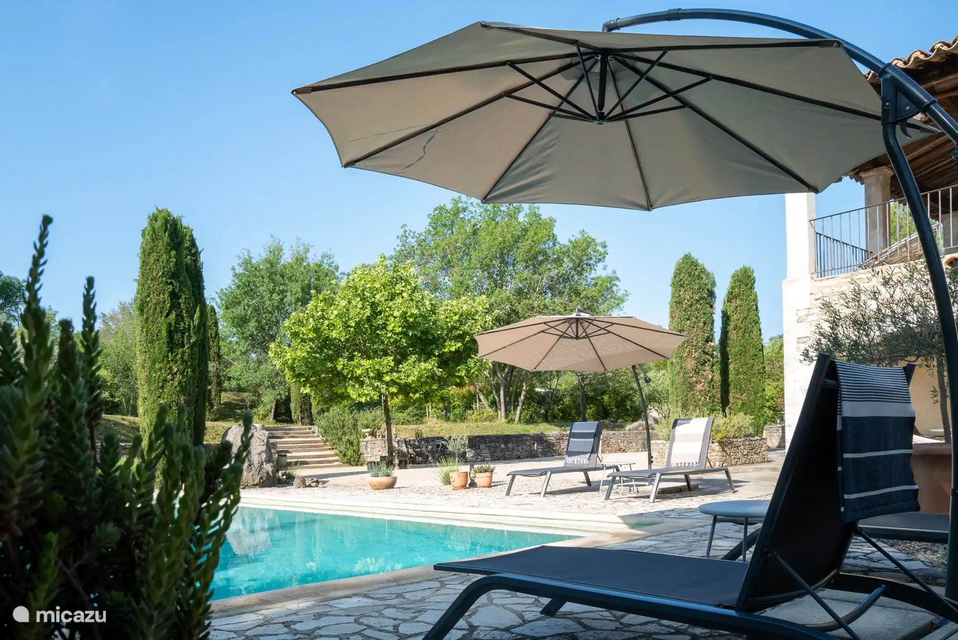 Belle piscine avec transats et parasols.
