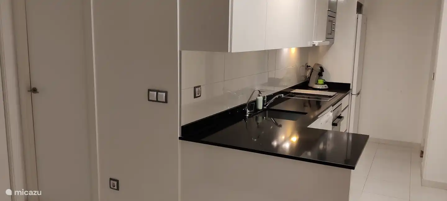 Küche mit L'OR-Kaffeemaschine, Backofen, Mikrowelle, Kühlschrank mit Gefrierfach, Toaster, Osmosemaschine und Geschirrspüler. Die Waschmaschine befindet sich in der Galeria