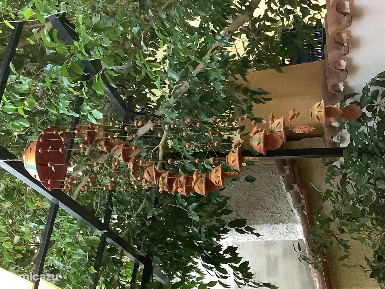 De windmobiel uit India boven de zithoek op het terras


