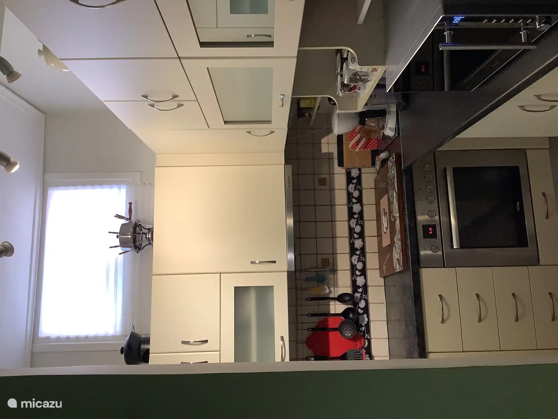 De keuken met het fornuis en de magnetron.