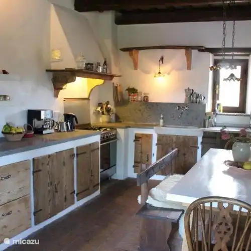 Cocina de estilo rústico totalmente equipada, equipada con todas las comodidades modernas, como nevera y horno SMEG, lavavajillas Miele y zona de comedor para 8 personas.