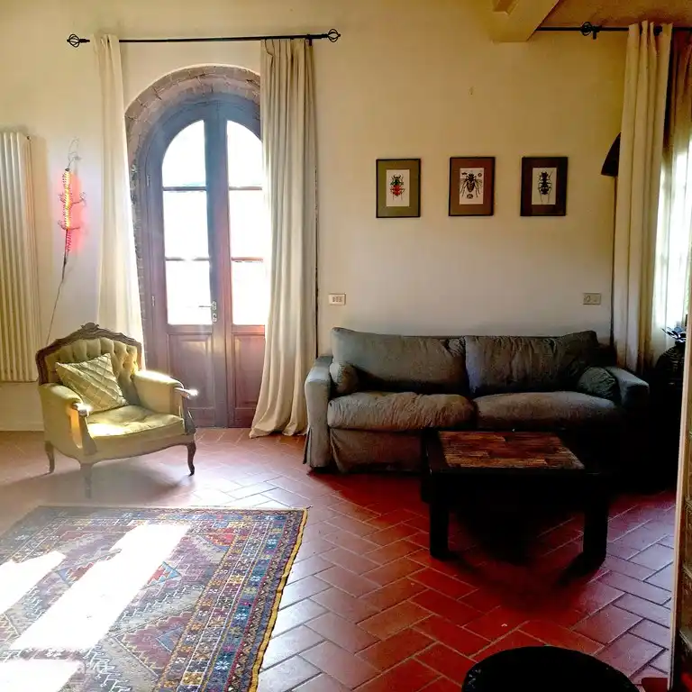 The living room, with three large French doors leading to the garden, the pool and to the private barn eating area just outside.