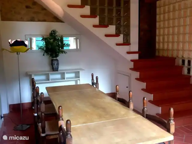 Location de Vacances Italie, Toscane, Lucca, villa - Grange toscane rustique La table à manger et les escaliers menant aux chambres, à l'étage. A gauche, dans le coin, il y a une quatrième salle de bain avec douche.