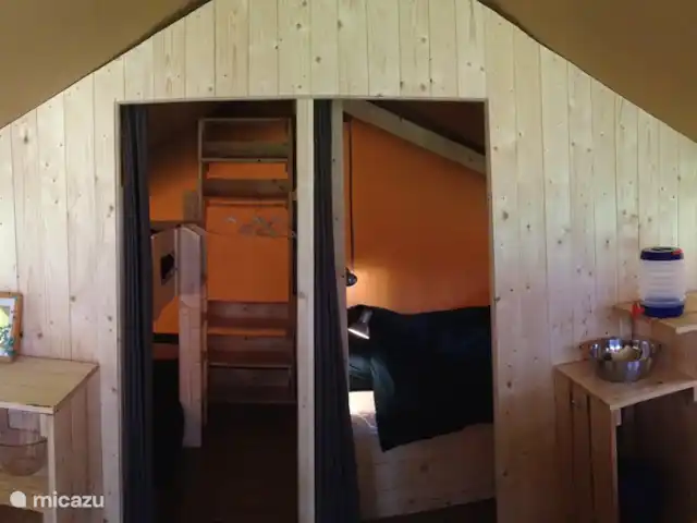 Ferienhof Brink Ort 3 en Alemania, Baja Sajonia, Warmsen - camping de lujo / yurta / tienda safari Los dormitorios están detrás de una partición de madera con una cortina en la sala de estar para mayor privacidad.