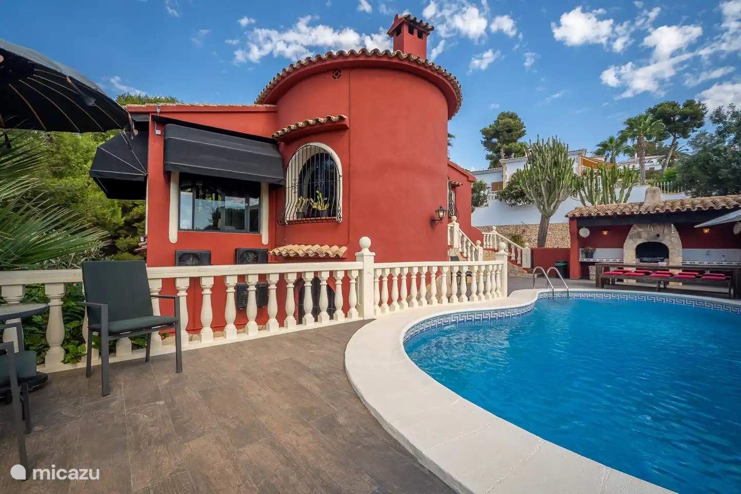 Vista lateral desde la piscina, los toldos completamente automáticos aseguran que siempre esté agradable y fresco en la casa.
