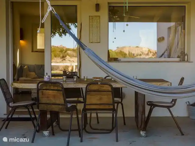 Leontine's Lodge in Sardinië huren in Italië, Sardinië, San Pantaleo - bungalow Voor-veranda met reflectie van het uitzicht in de ramen op onze gigantische 'schildpadrots' aan de overkant.