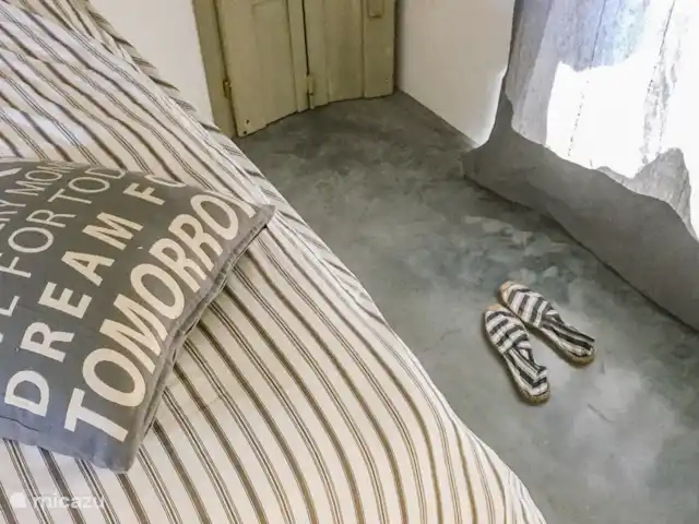 Leontine's Lodge in Sardinië huren in Italië, Sardinië, San Pantaleo - bungalow Koele cement gestorte vloer met bed van 1:60 breed in de nis tussen de klerenkasten met deurtjes van antieke raamluiken