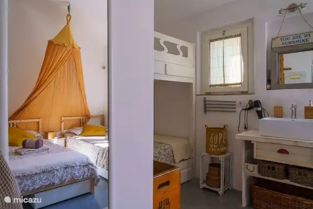 Schauen Sie in den Spiegel des Familienzimmers, um zu sehen, wie sich die Betten zueinander verhalten. Dieses Zimmer verfügt über das über den Flur zugängliche Badezimmer mit Regendusche, WC mit Brausehahn und Waschbecken, eine zusätzliche Außendusche im Garten davor und ein zusätzliches Waschbecken im Zimmer.