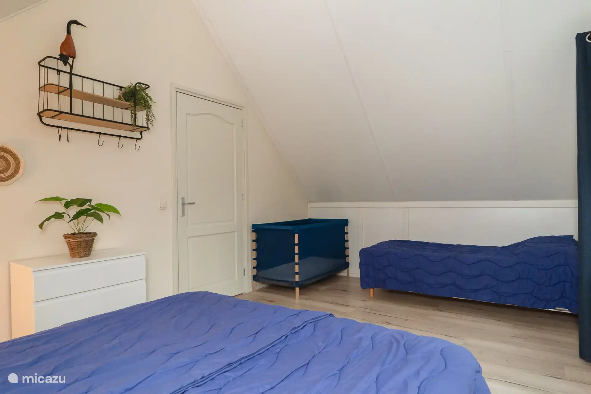 Chambre avec 3 lits et 1 lit bébé.