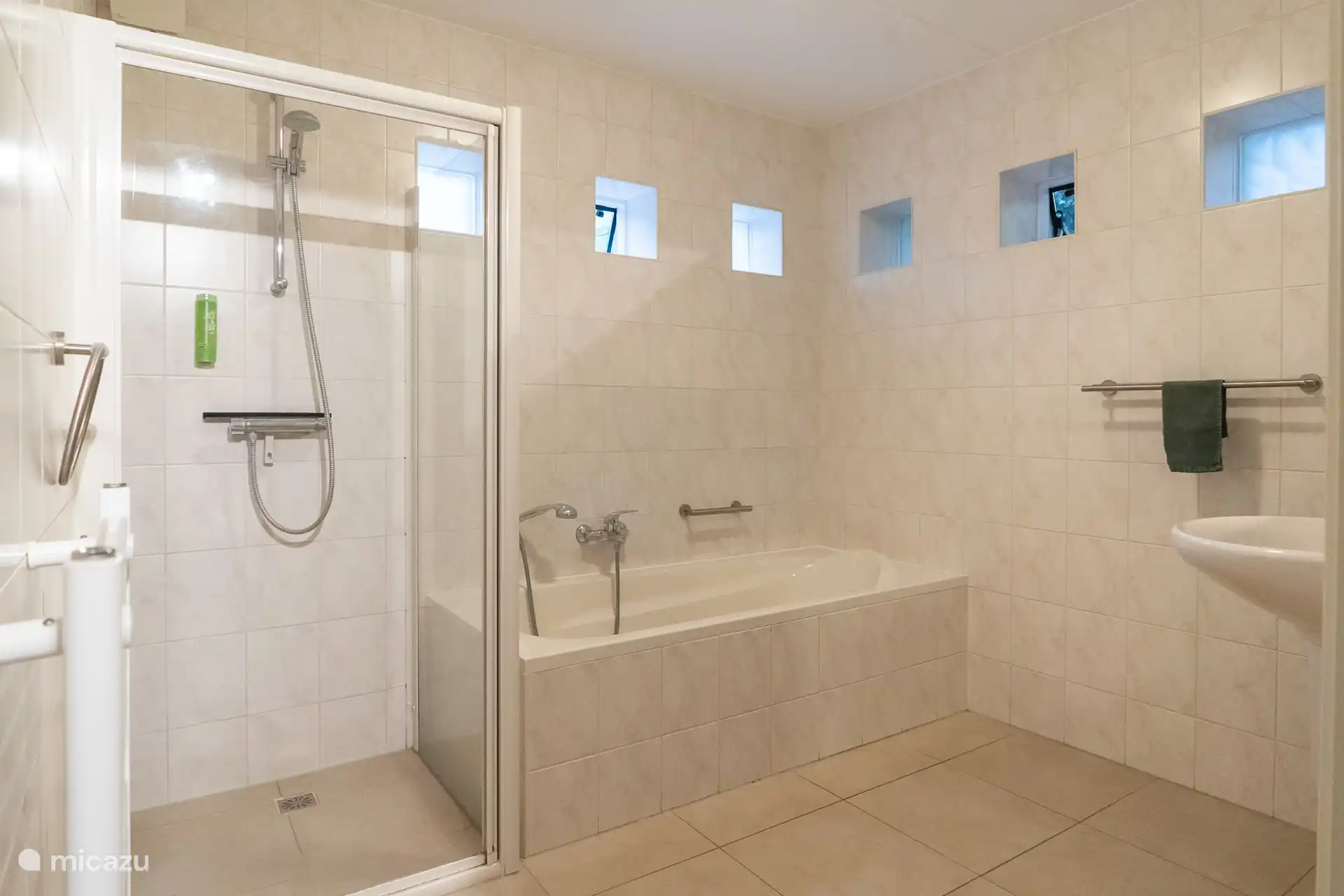 Salle de bain au rez-de-chaussée avec douche, baignoire et lavabo.