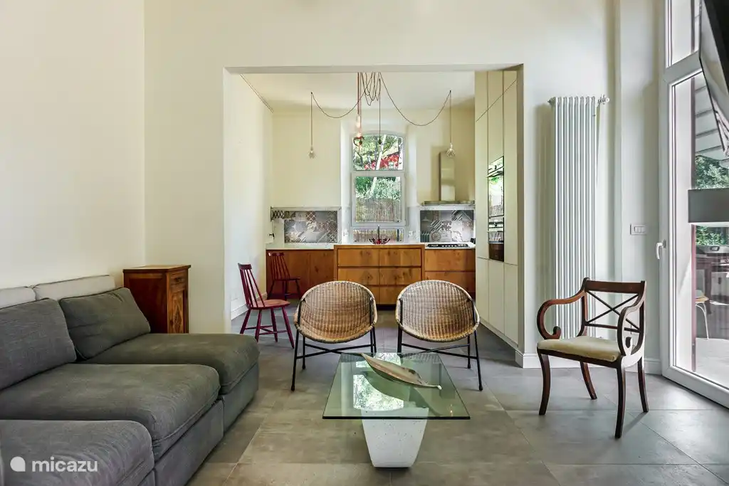 La sala de estar con chimenea, cocina y una vista de la hermosa terraza y jardín.