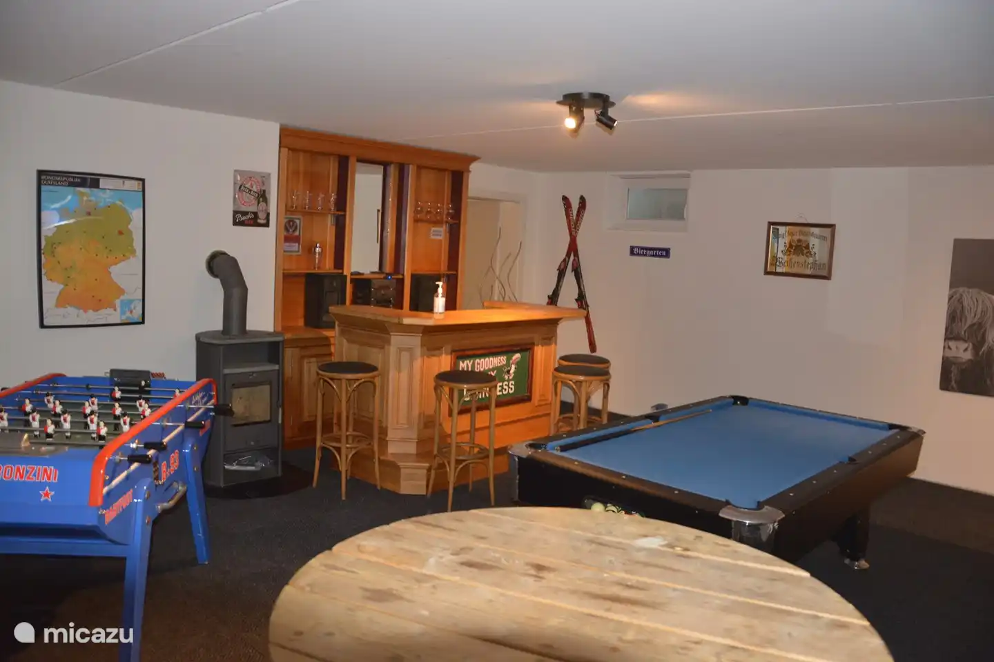 In the basement is the games room with a cozy bar, pool table, dart board, table tennis table and a real Bonzini match football table