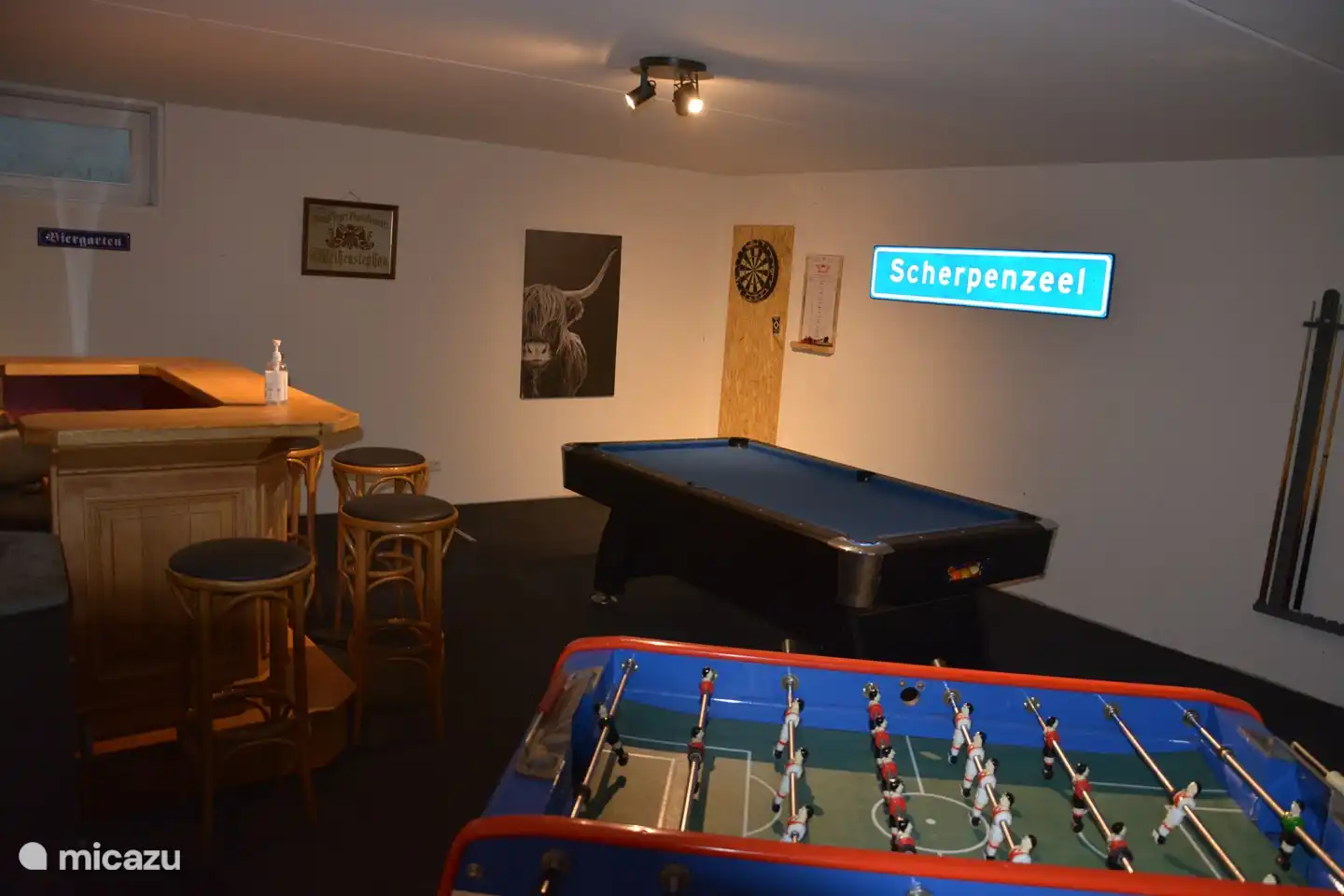 In the basement is the games room with a cozy bar, pool table, dart board, table tennis table and a real Bonzini football table