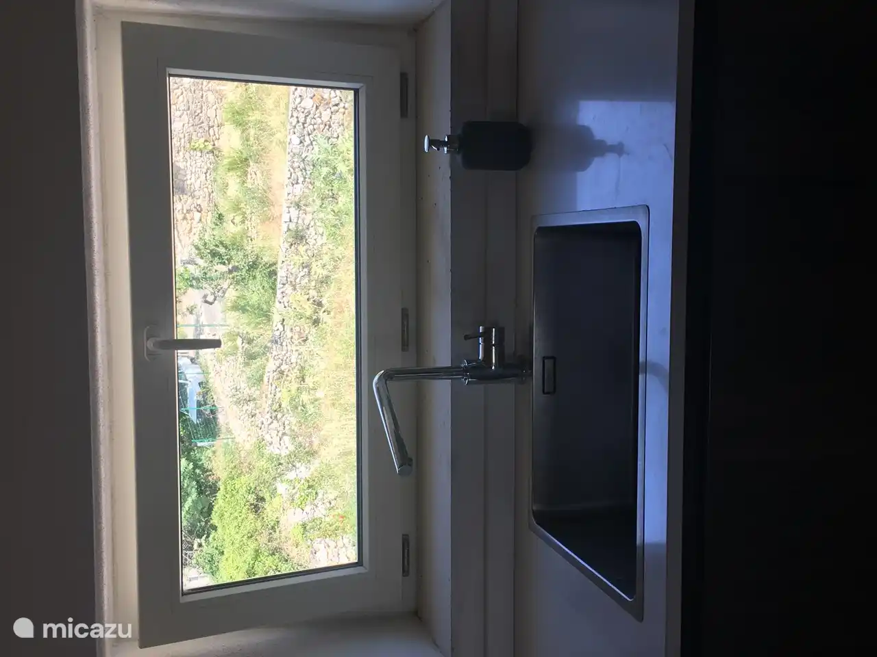 Küchenarmatur und Blick auf die Rückseite des Hauses