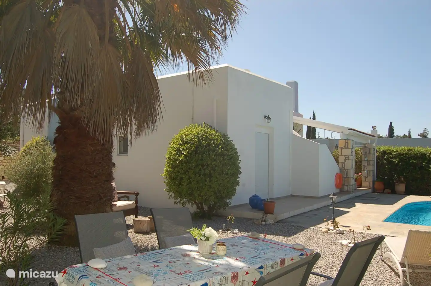 Dining table in the garden overlooking the pool, garden and the villa