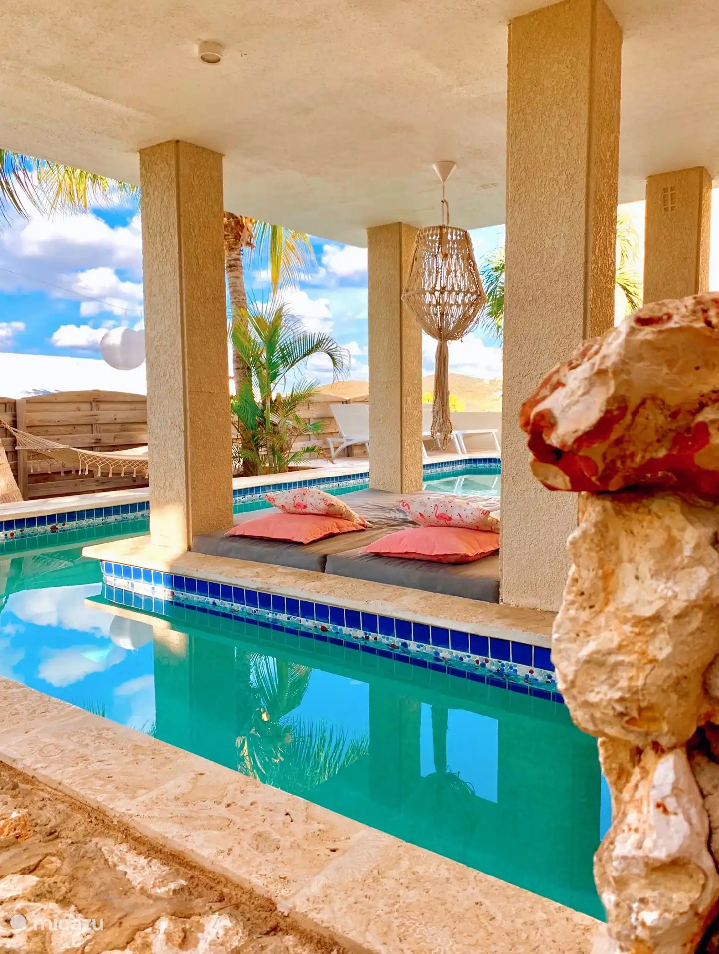 La piscina con varias tumbonas. 