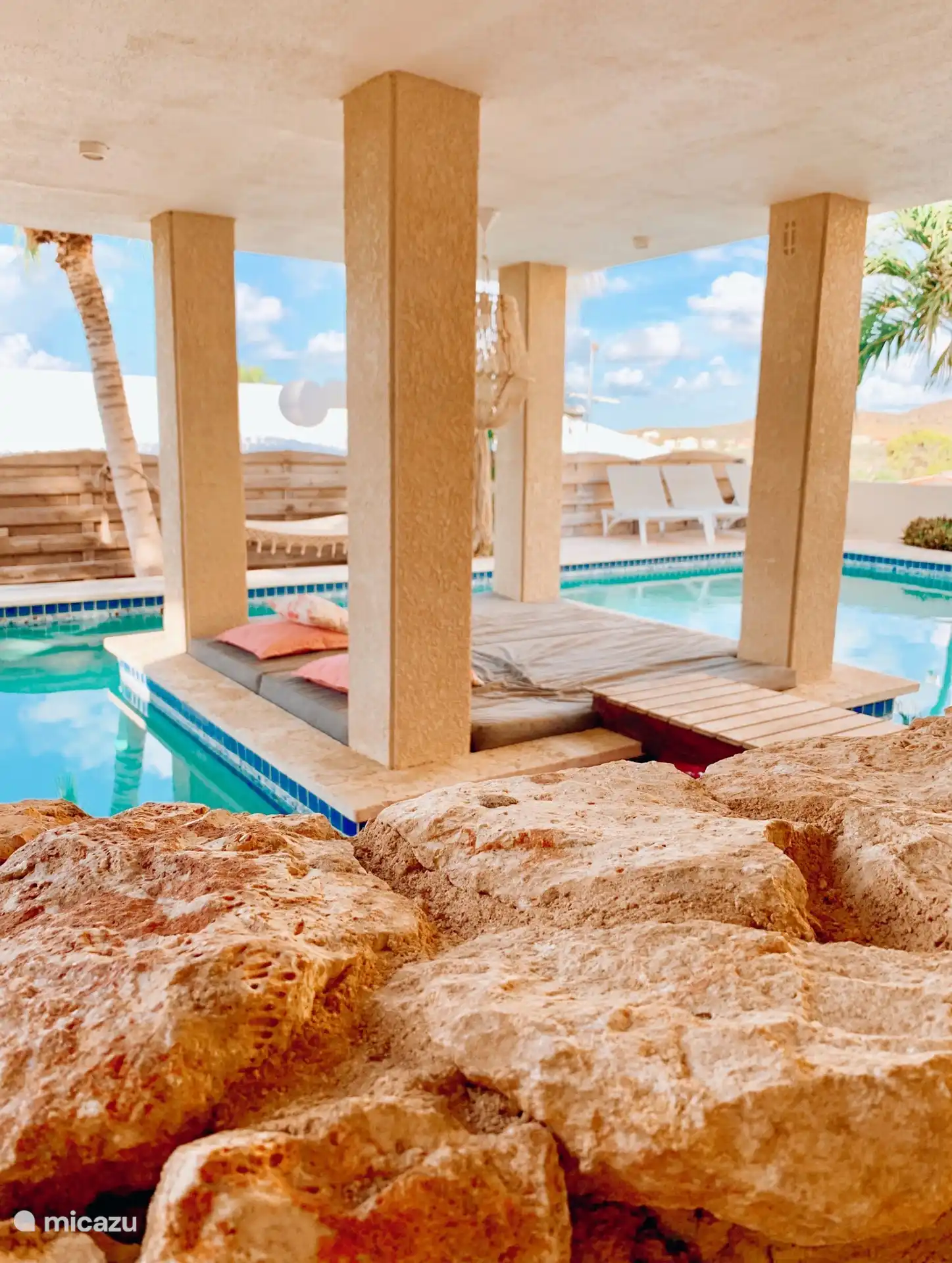 La piscina con varias tumbonas. 