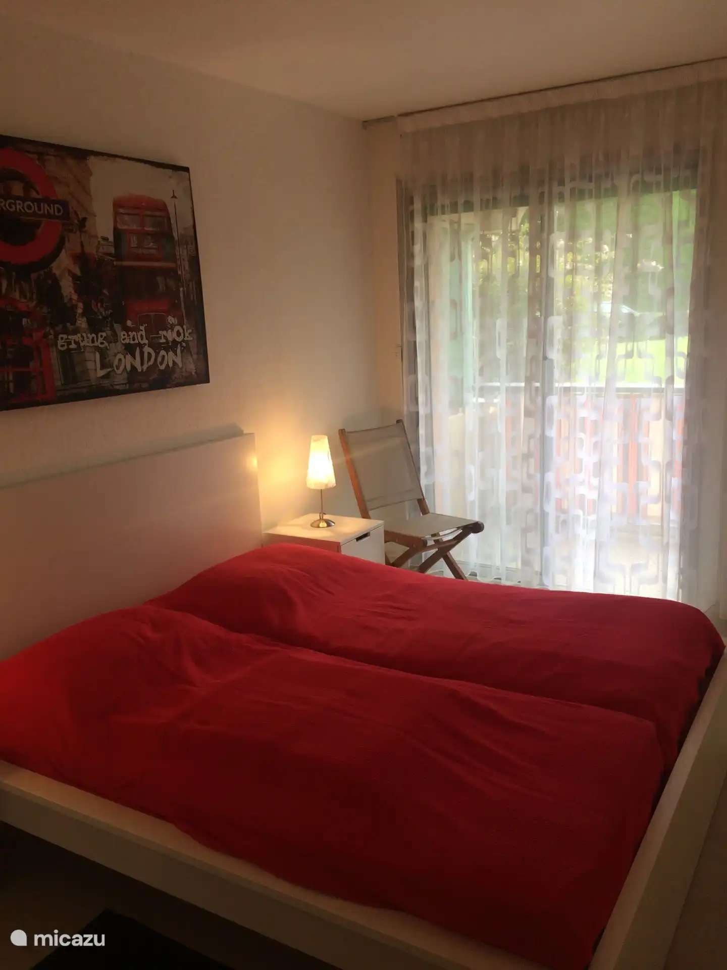 This bedroom is adjacent to the small bathroom.