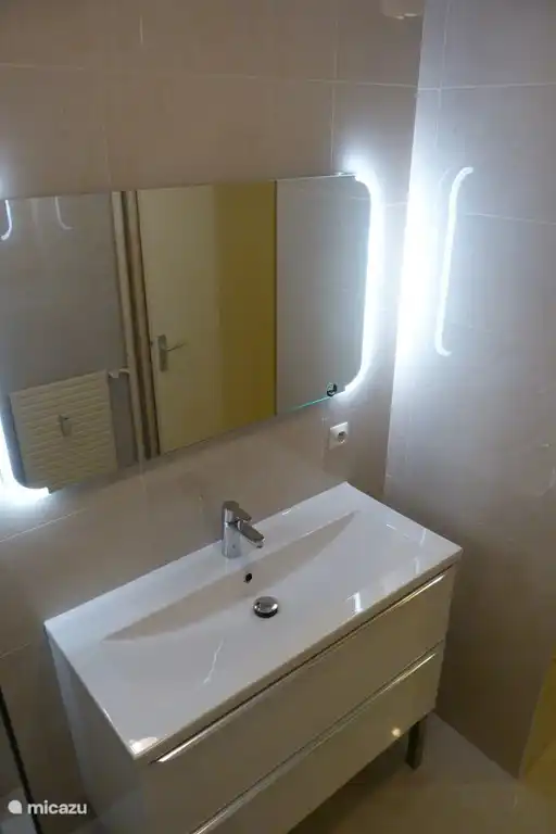 Ein modernes und geräumiges Waschbeckenmöbel mit beleuchtetem Spiegel