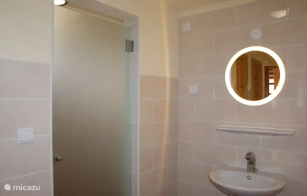 Grote douche met wastafel in voorportaal.