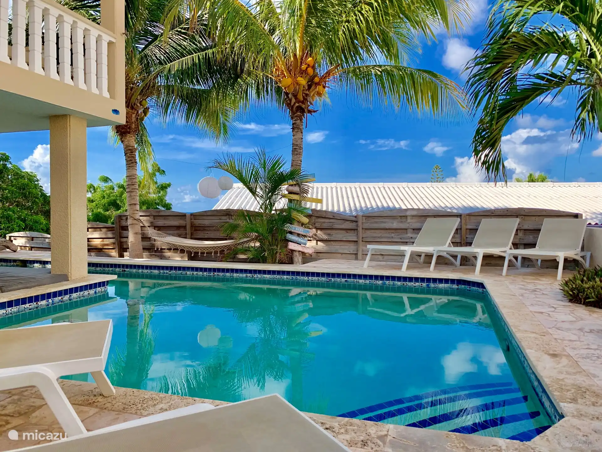 Verschiedene Sonnenliegen rund um den Pool.