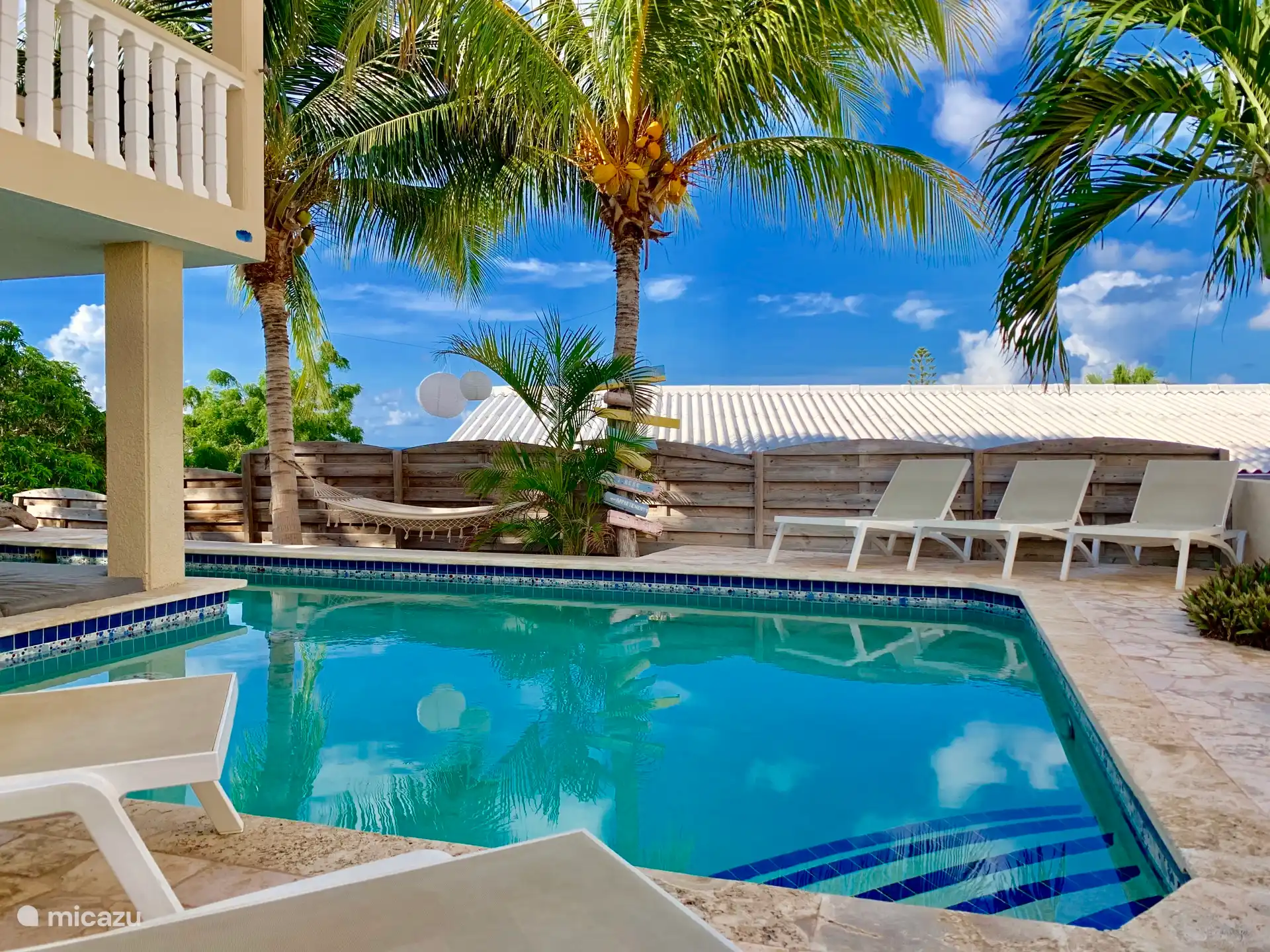 Zwembad met ligbedjes en hangmat