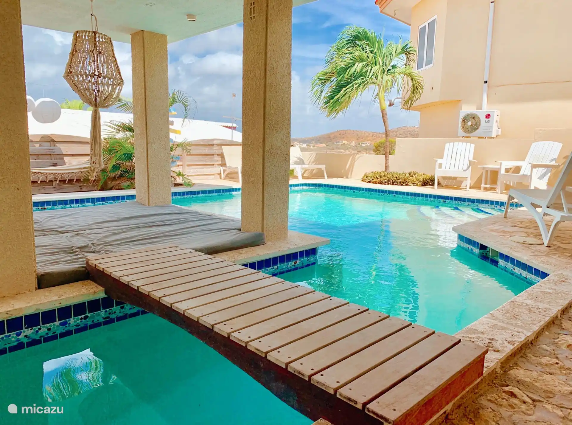 Piscine avec espace salon et chaises longues