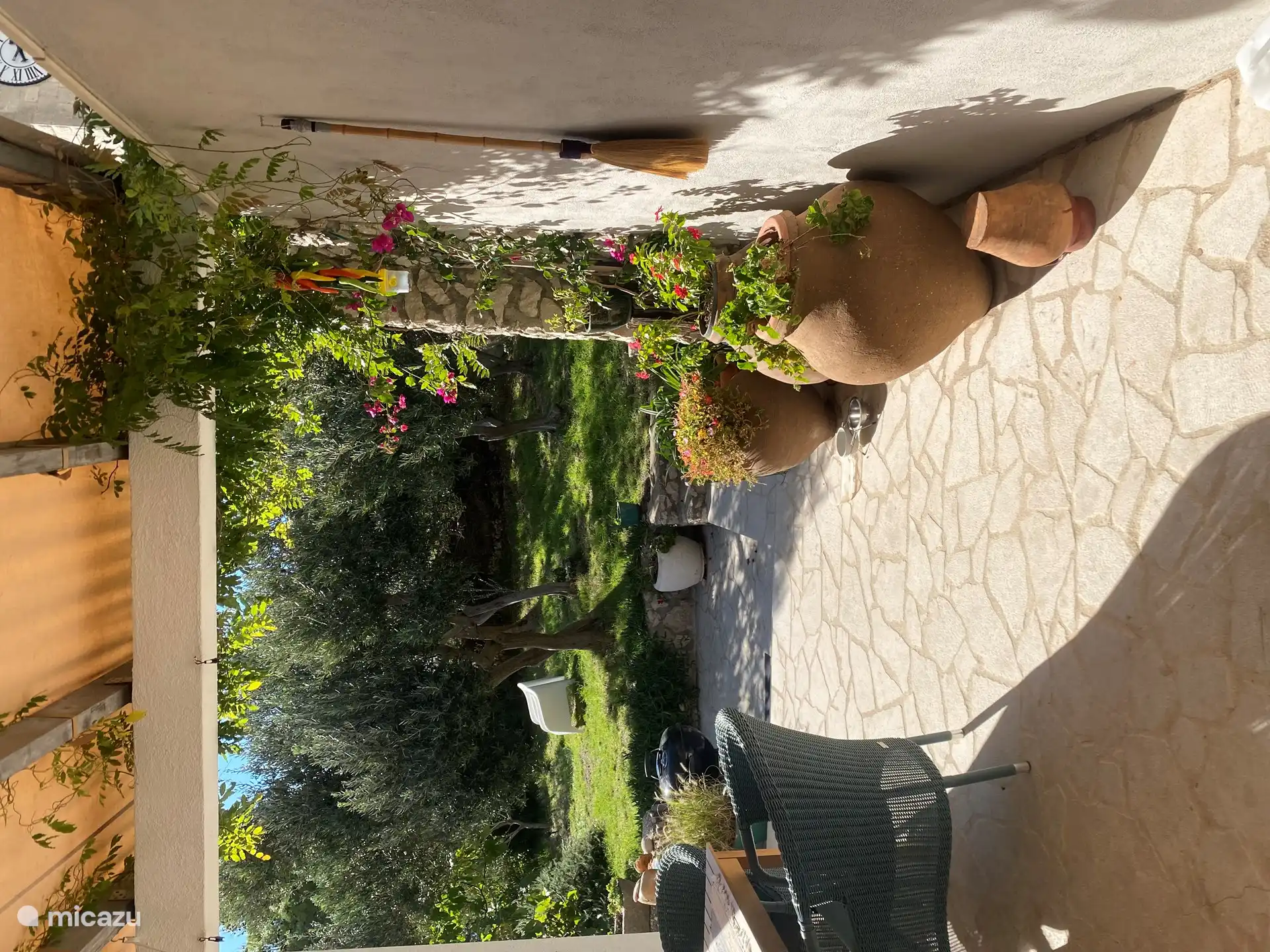 Desde la cocina vista a la terraza. Con flores dobles floreadas en macetas de olivo español.