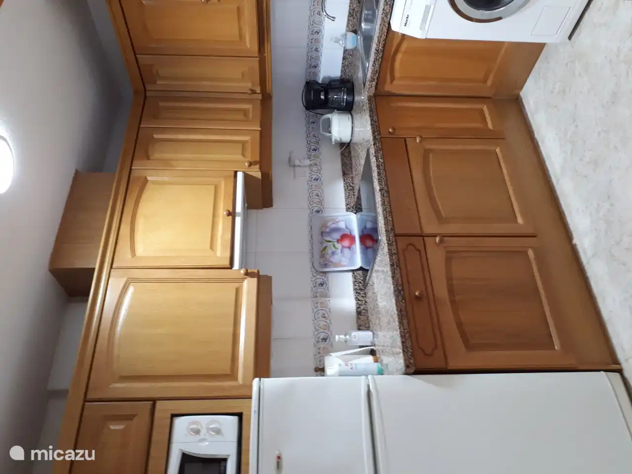 Kitchen with ceramic hob, fridge, freezer, microwave, washing machine.