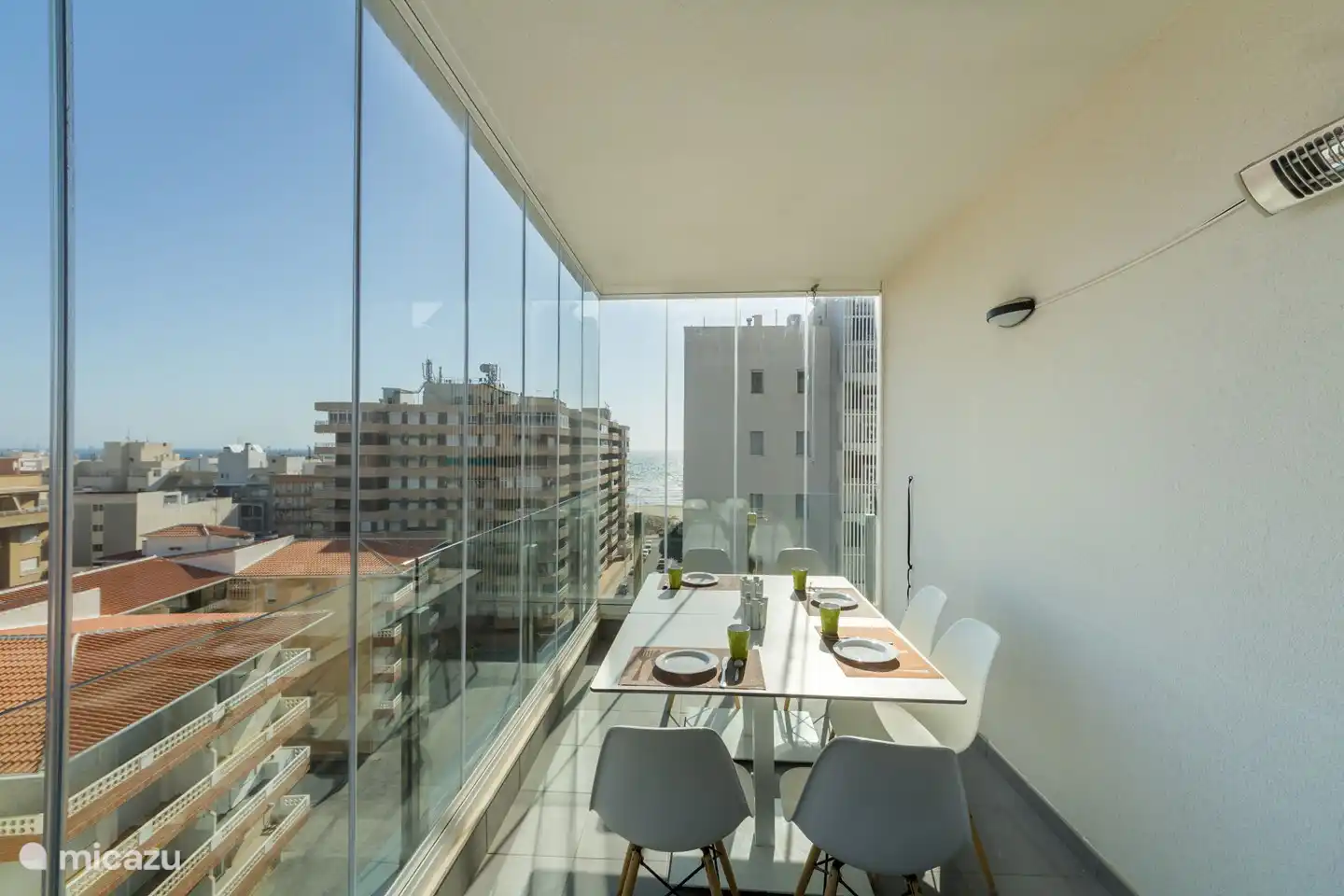 Vue de la terrasse, protégée par des rideaux de verre, et vue sur la mer