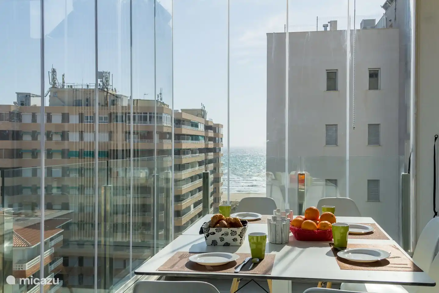 Vue de la terrasse, protégée par des rideaux de verre, et vue sur la mer