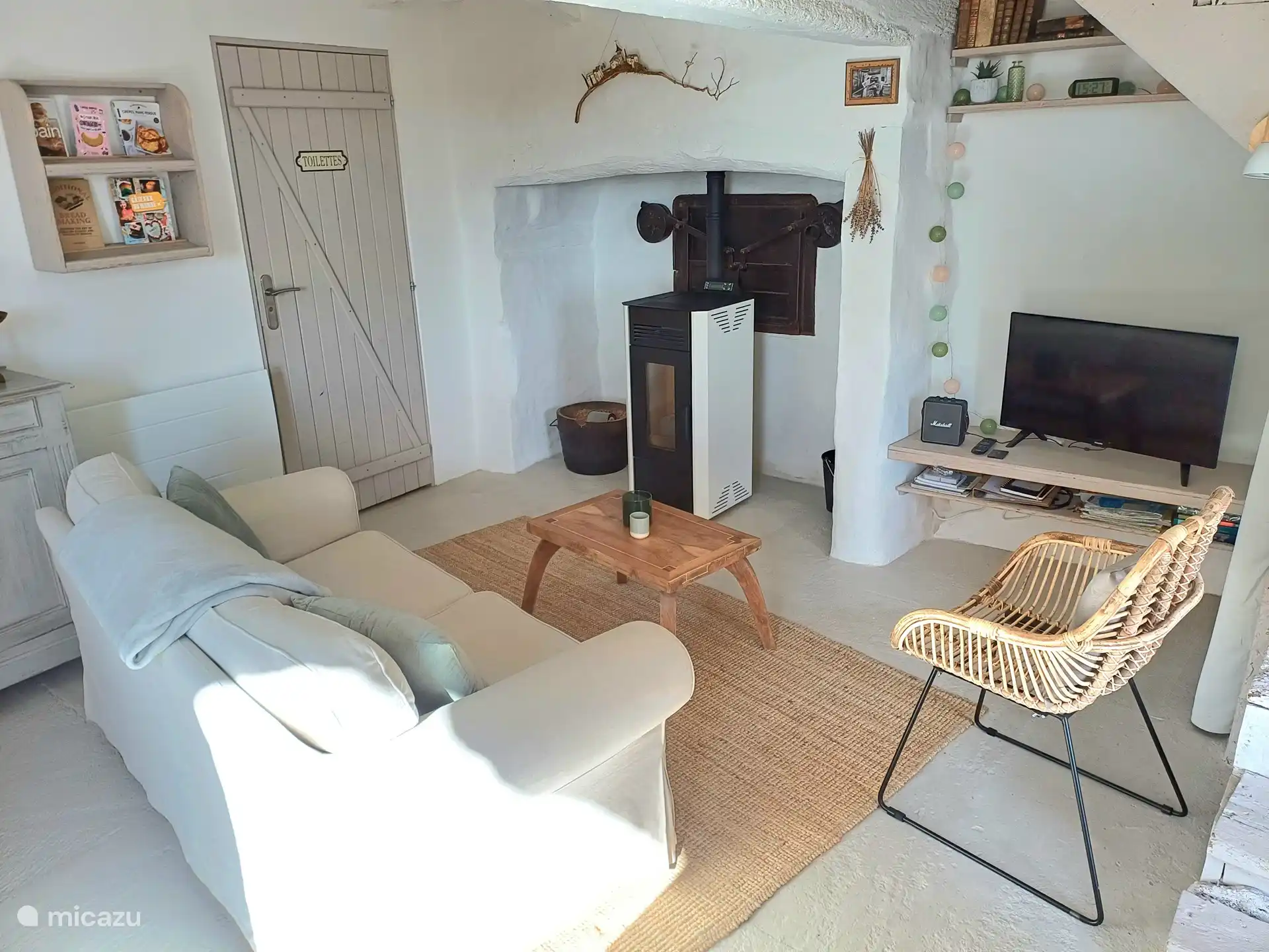 Wohnzimmer mit Pelletofen und Smart-TV.