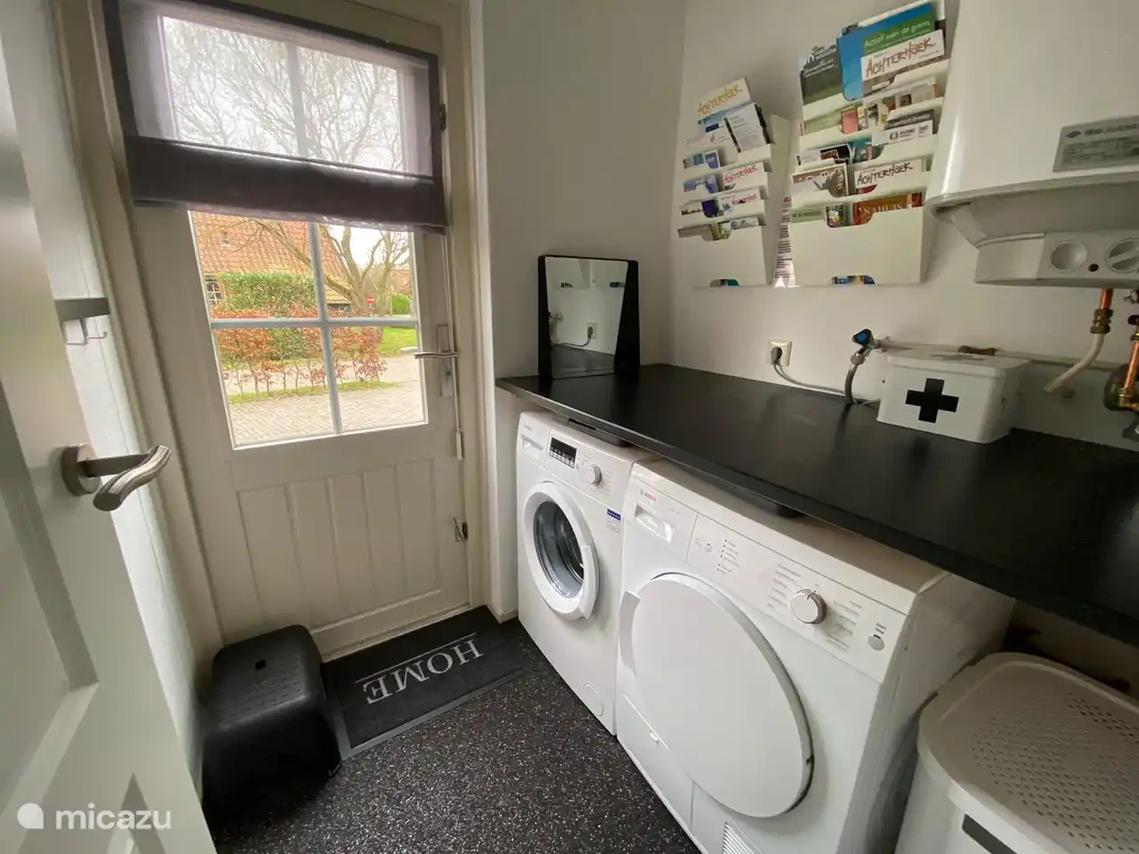 Der Hauswirtschaftsraum ist mit einer Waschmaschine und einem Wäschetrockner ausgestattet. 