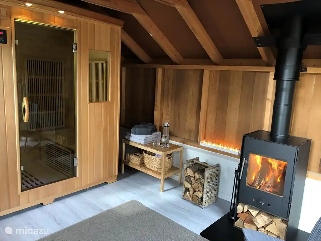 Zum Haus gehört auch ein Ruheraum mit einer 4-Personen-Infrarotsauna und Holzofen (dieser kann optional gebucht werden). 