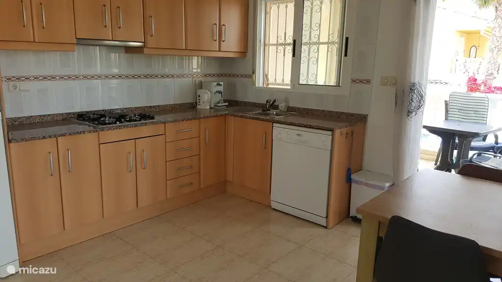 Luxuriöse Küche mit Senseo-Kaffeemaschine, Geschirrspüler, Backofen und dergleichen. 
