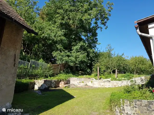 gîte / cottage huren in Tsjechië, Liberec, Levousy – Cottage Levousy tuin met links de stenen schuur en rechts het huis