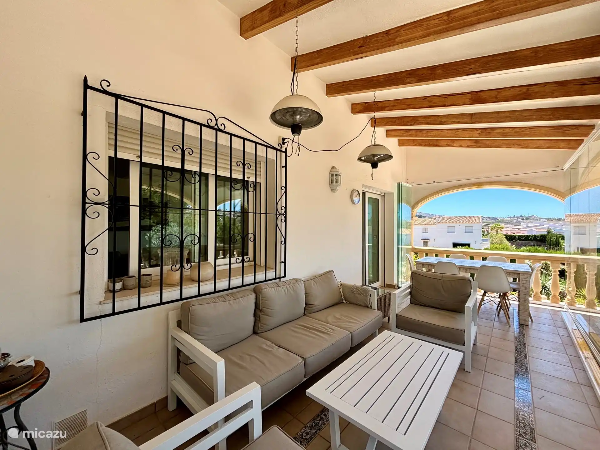 Veranda mit 6-Personen-Tisch und Sitzecke. Die Veranda hat eine versenkbare Glaswand