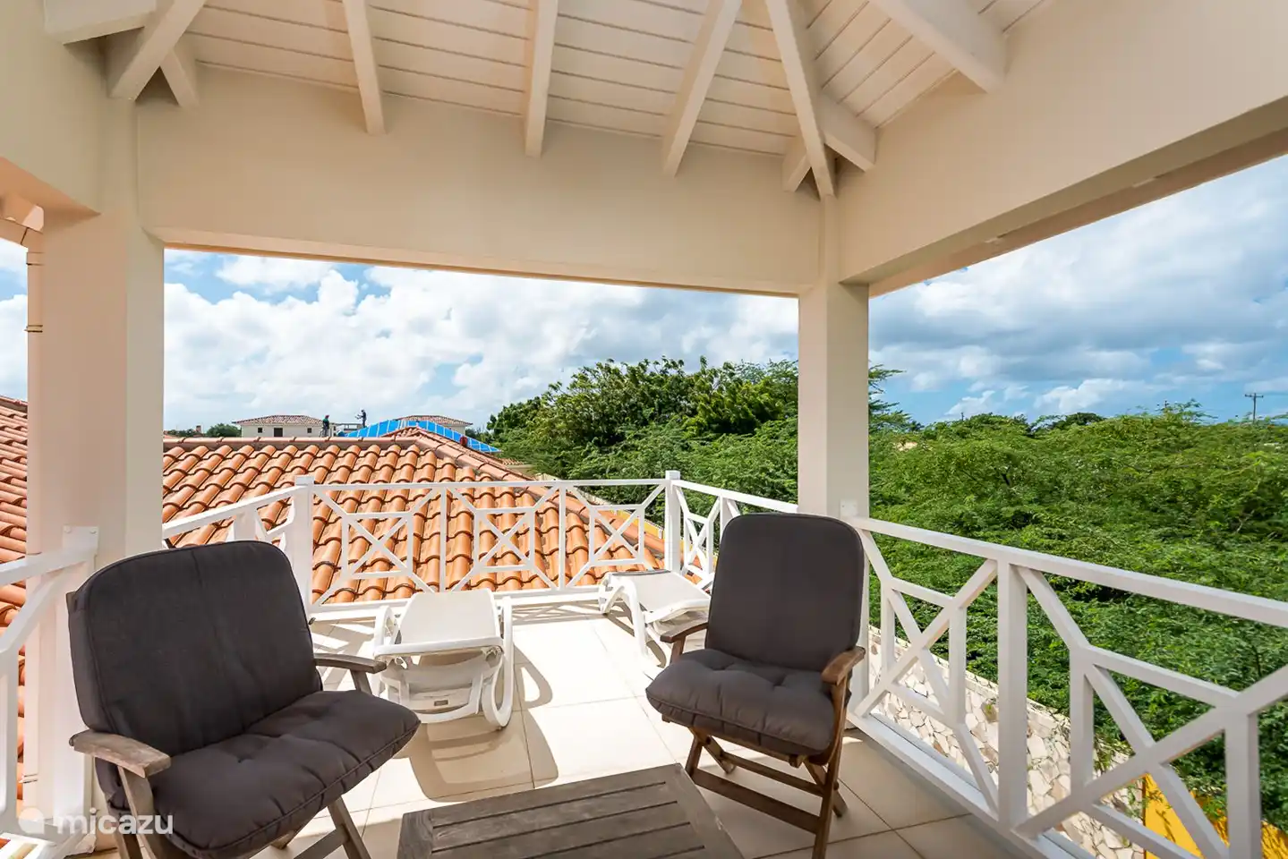 Het overdekte boven terras heeft  een teakhouten zithoek alsmede 2 ligbedden om heerlijk te zonnebaden