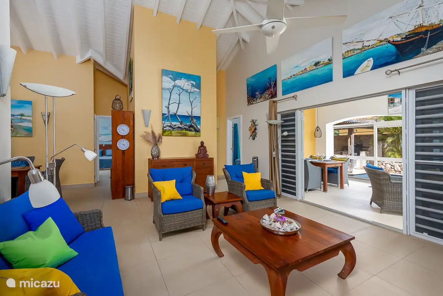 De woonkamer is  sfeervol ingericht .Doordat de deuren volledig open kunnen ontstaat er in combinatie met het overdekte terras een zeer royale leefruimte.
2 Plafond ventilatoren met afstandsbediening zorgen voor verkoeling