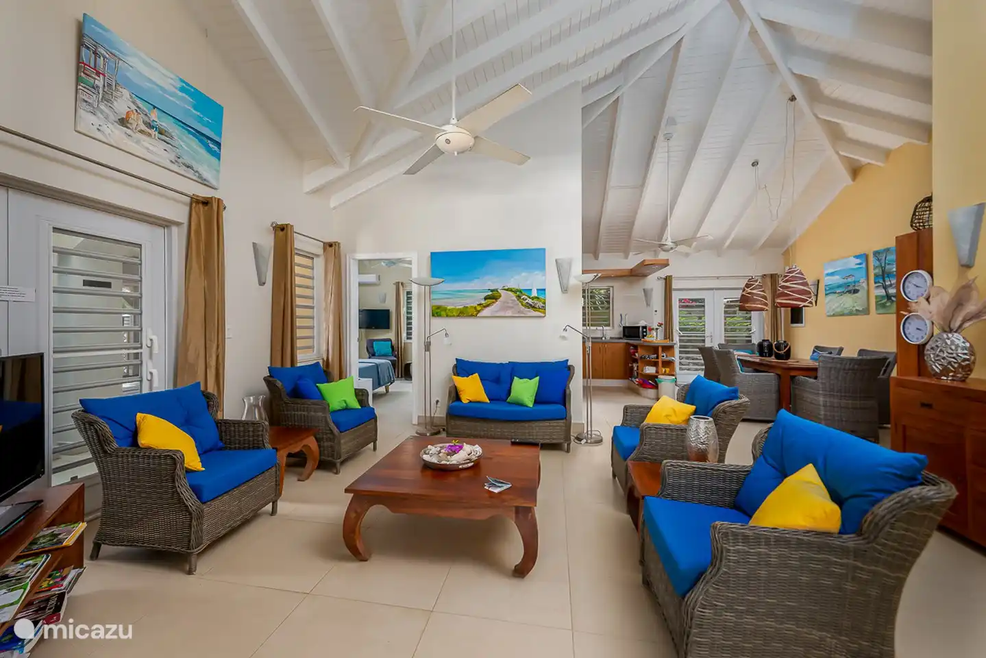 Ook in de woonkamer wordt u omgeven door de prachtige landschappen van Bonaire. Verder geven de koloniale teakmeubelen een warme sfeer. De plafonds van de woonkamer zijn tot 4,5 meter hoog, wat een zeer ruimtelijk effect geeft.
2  plafond ventilatoren zorgen voor  de verkoeling